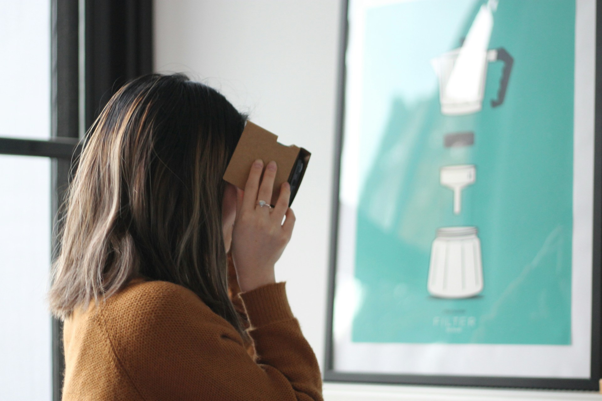 Woman looking through a Google Cardboard virtual reality headset